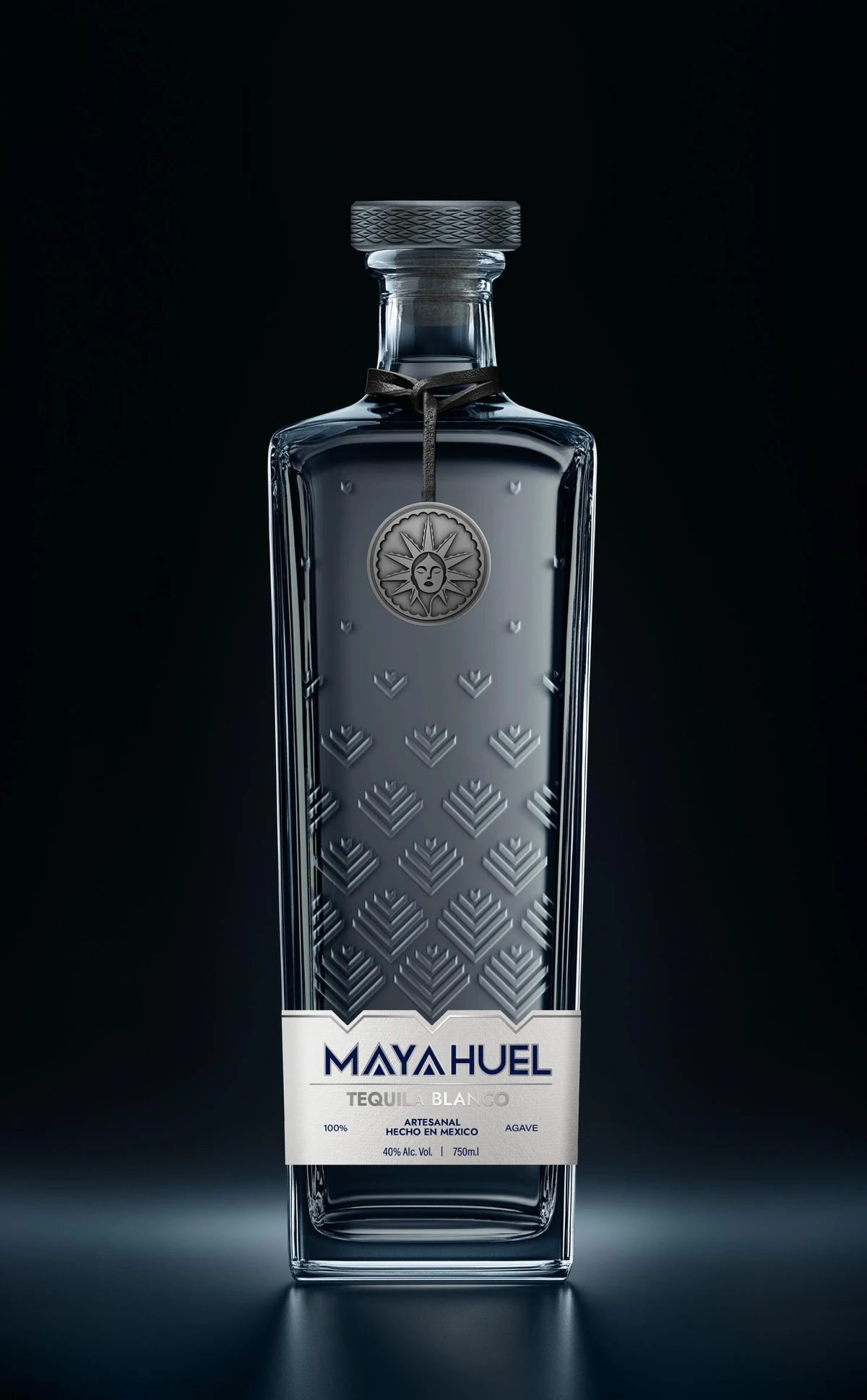 Botella de Mayahuel Tequila Blanco: vidrio transparente con pencas en relieve, medalla plateada con un rostro al centro de un sol y tapón gris con relieve tejido