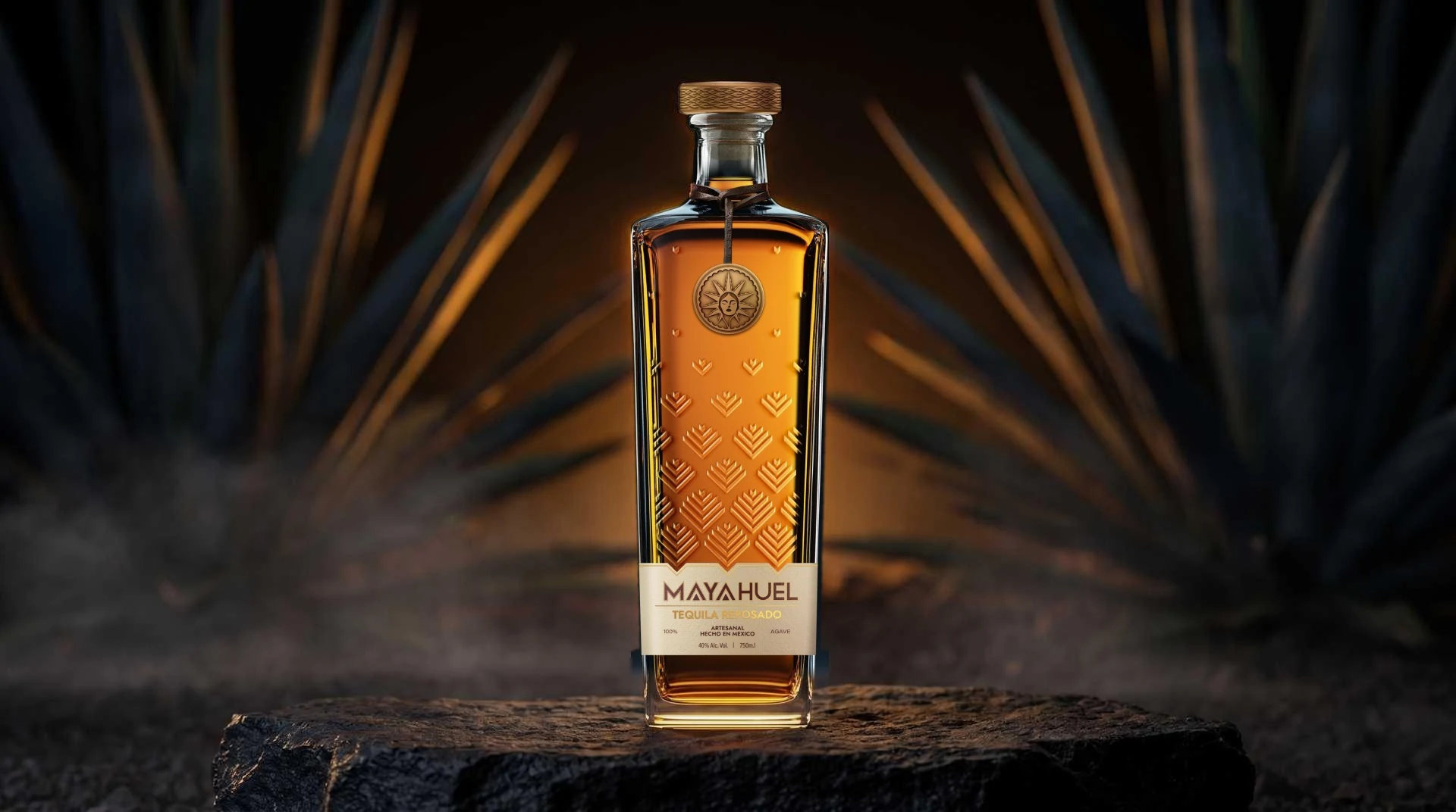 Botella de Mayahuel Tequila Reposado sobre una losa de basalto, de noche, entre pencas de agave encendidas en ámbar y una bruma baja